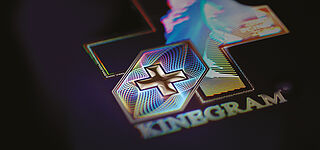 KURZ Technologies are the gold standard for secure banknotes Close-up of a KINEGRAM® security feature showing guilloche shaped fine lines and a Swiss Cross in 3D
