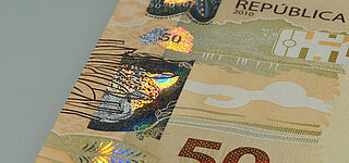 Get in touch for more information Close-up of a Brazilian 50 Real banknote with a partially metallized KINEGRAM® showing a leopard and jungle leaves